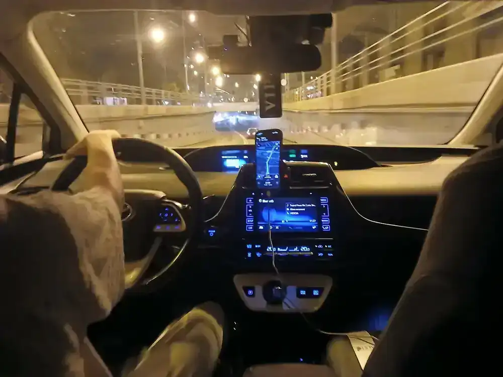 A Bolt ride at night — the route on the driver's phone, the fare already fixed in the app