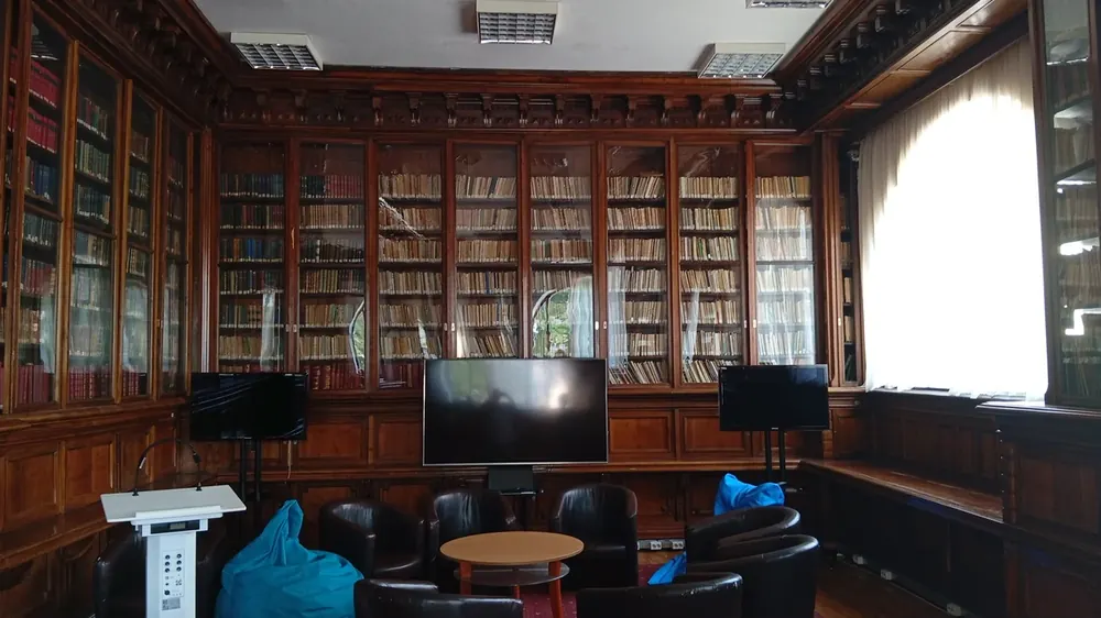 The reading room — glazed walnut cases on every wall, screens and tub chairs in front