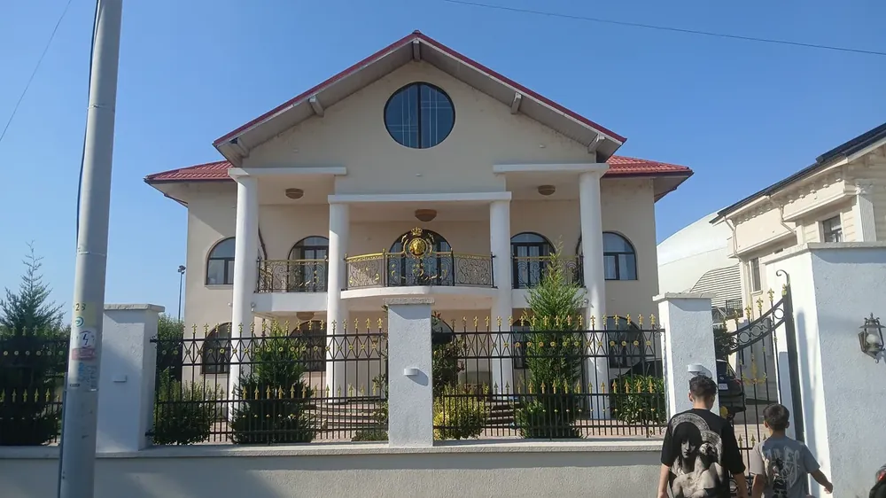 A villa on the streets behind the Oblemenco stadium — columned porch, round gable window, gilded balcony ironwork