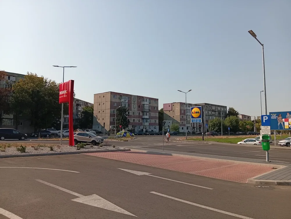 The Penny and Lidl totems on Bulevardul Dacia in Craiova seen from the shared car park, apartment blocks behind