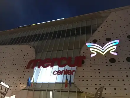 The Mercur Center sign and lit butterfly logo on the perforated facade at night