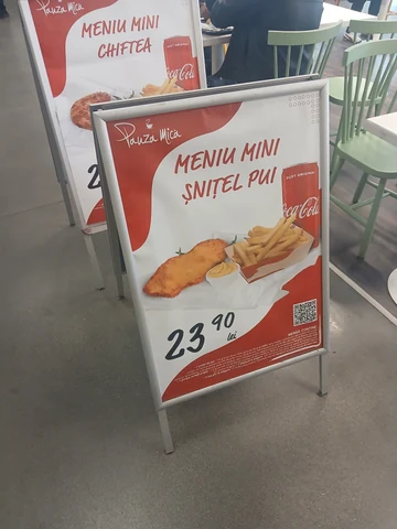 The Pauza Mica boards by the tables — mini schnitzel menu at 23.90 lei in front, the chiftea menu behind. 26 September 2026