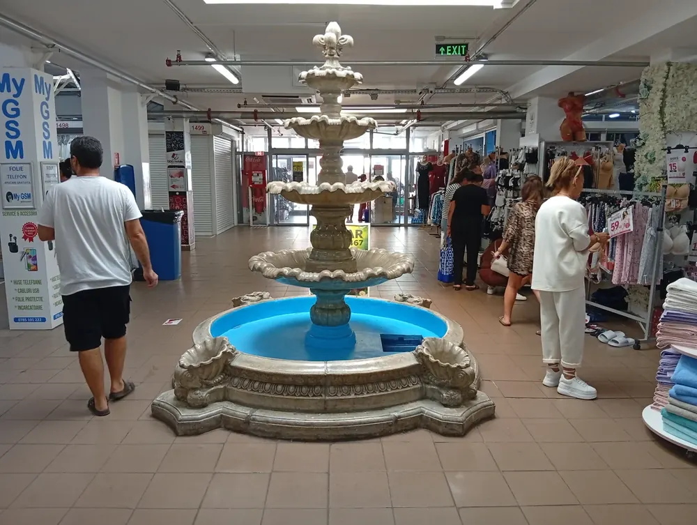 The fountain in the middle of one hall, stands and a phone counter around it