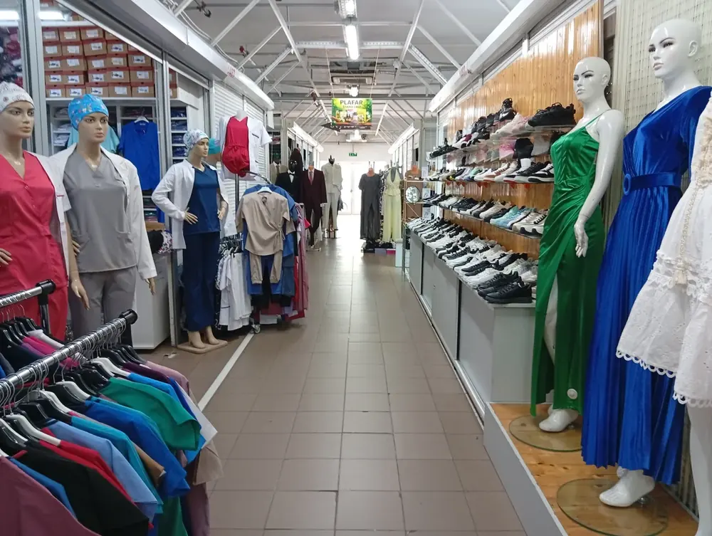 An aisle of workwear and medical scrubs, trainers on the shelves opposite