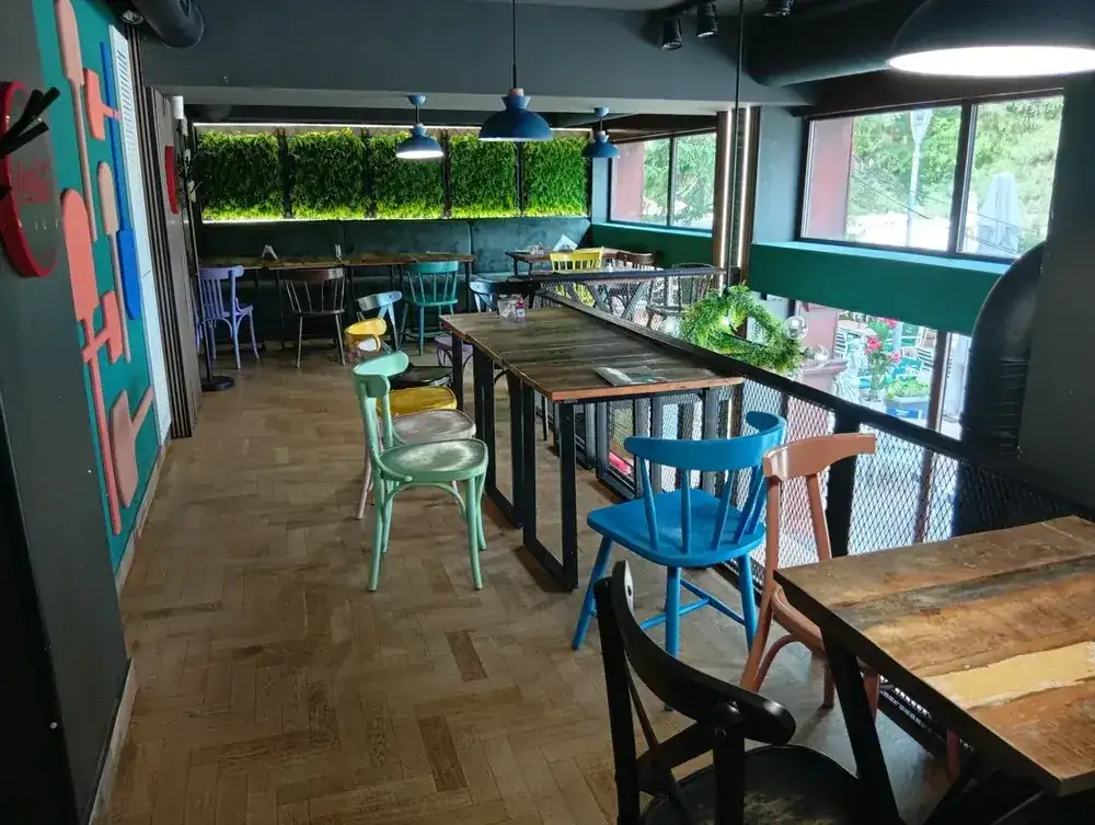 The upstairs room — painted bentwood chairs, long tables, moss wall