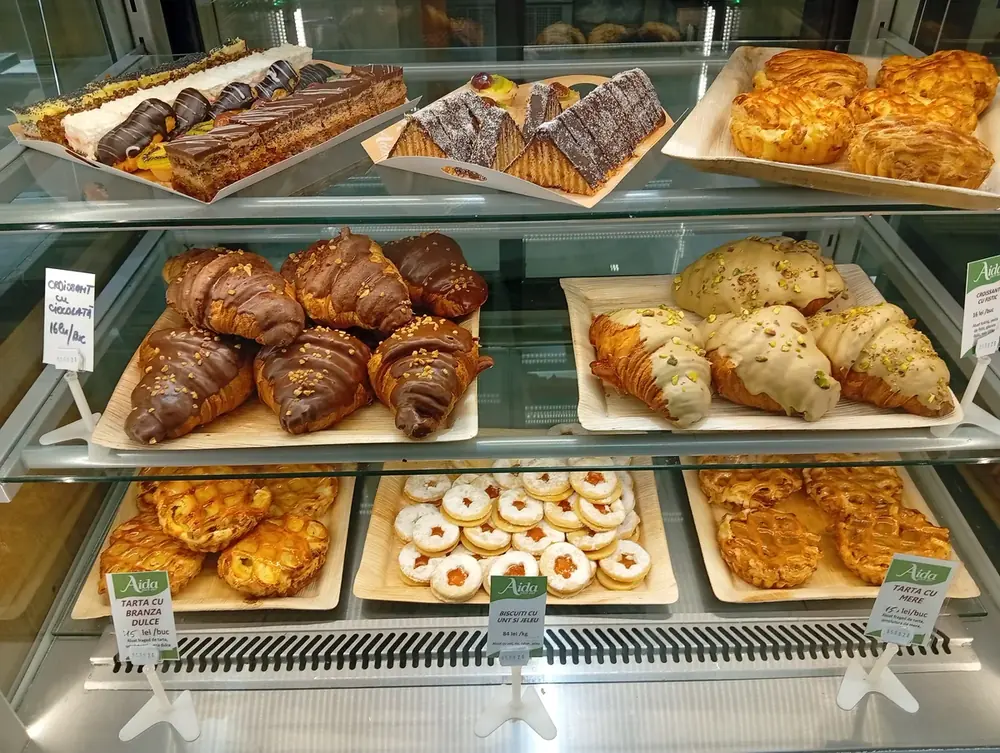Dry baking sold by weight — cheese pretzels, jam cornulete and walnut cornulete, all 66 lei a kilo. September 2026
