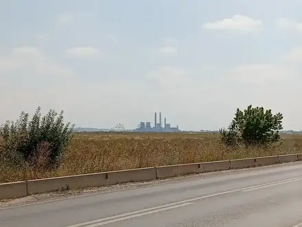 The Işalnița power station on the horizon across open farmland north-west of Craiova